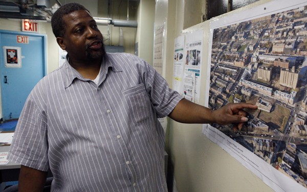 Milton Bolton, the president of the tenants association at Prospect Plaza, points to plans for what will take the place of the high-rise housing project in Brownsville. It was emptied in 2002 for what was supposed to be a renovation and now will be a demolition.