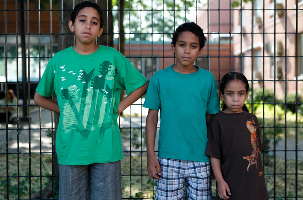 Brothers Erickson Morales, 10, Erick Morales, 9, and Roeriel Morales, 5, pose outside the PATH Center in the Bronx, where they are currently living. They are enrolled in PS 399 in Brooklyn in the fall, but they do not know where they will be living when school starts.