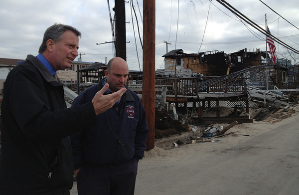 Public Advocate Bill de Blasio touring storm-damaged Breezy Point in November. After the Newtown shooting, de Blasio called for the city's pension funds to divest from gun companies. The NRA, meanwhile, says post-Sandy looting is an argument for all responsible citizens to arm themselves.