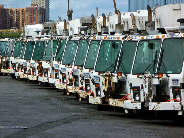 Department of Sanitation garbage trucks sit idle in a parking lot. Because the city doesn't haul commercial waste, it has had little information about how much businesses are actually recycling.