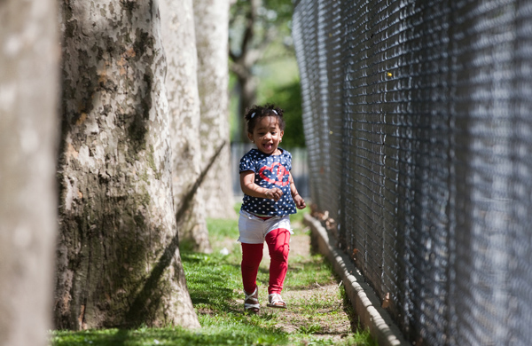 Madeline Alcanatara, 2 years old, runs along the fence of a playground in the Wagner Houses in census tract 192, one of the poorest in the city.