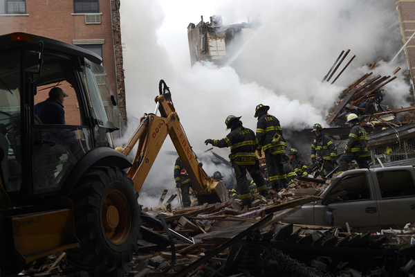 Firefighters search through the rubble of two buildings in Harlem that exploded Wednesday morning. The death toll was expected to rise.