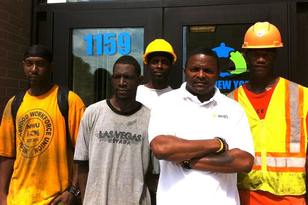 Construction workers with Andre Mitchell, in white shirt, the executive  director of Man Up! and lead negotiator of the Community Benefits Agreement for Gateway II.