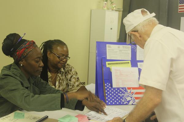 Inspectors Laronda V. Lockert and Diane Stafford assist voter Agustin Gonzalez at the Glebe Avenue Senior Center polling station.