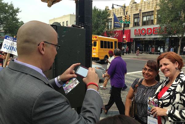 State Senator Gustavo Rivera, left, was doing everything he could to help Quinn’s campaign in the Bronx. Frequently he would start a sentence in English and end it in Spanish, as he sought to rally the support of spanish speaking voters. Here he plays photographer for the greatful Miriam Torres.