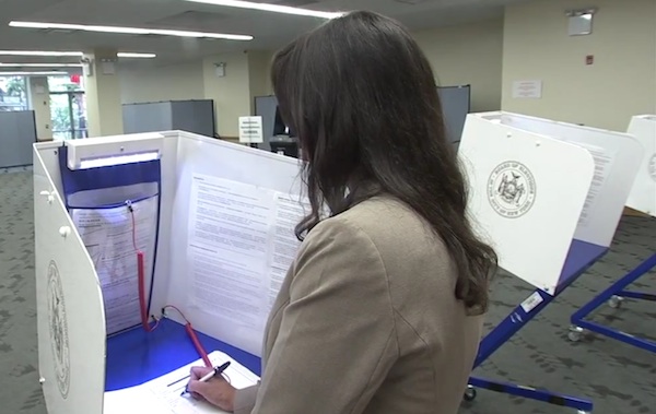In a scene from a Board of Elections instructional video, a voter uses the 