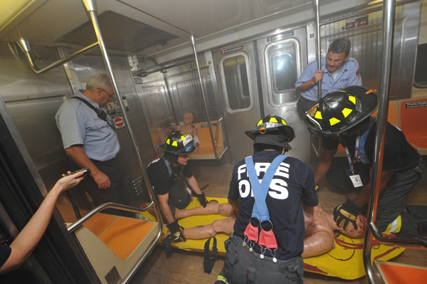 The author (left) and teammates Peter Haskell of CBS News Radio (center) and Mark McMillan from the Queens Borough President's office, rescue a victim of a subway bombing during a Fire Ops 101 drill.