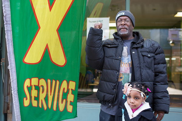 Danny Taylor poses with his daughter outside a tax preparation business